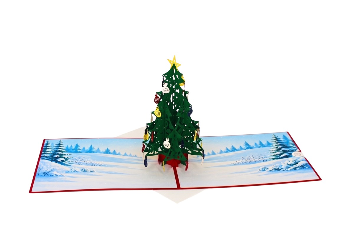 Aufgeklappte Pop-up-Weihnachtskarte mit aufgestelltem Weihnachtsbaum vor einer verschneiten Winterlandschaft